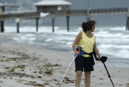 A woman, gave her name as Leslie, searches Dania Beach, Fla. Thursday, Aug. 25, 2011 for treasures as a Hurricane Irene feeder band moves ashore. She said she had only found a penny, a couple of bottle caps and too many jelly fish washed ashore. (AP Photo/J Pat Carter)