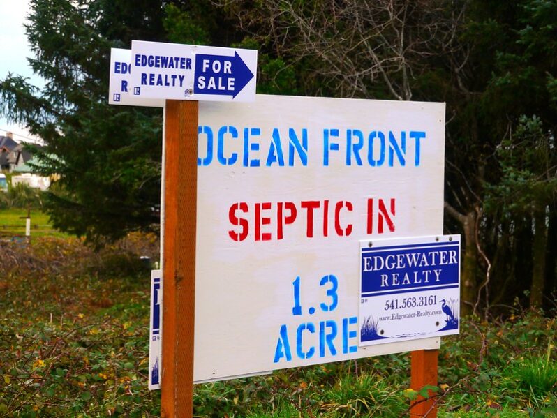 Ocean front property for sale sign south of Yachats, Oregon (by Rick Obst CC BY 2.0 via Flickr).