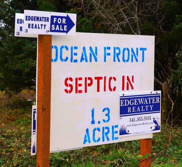 Ocean front property for sale sign south of Yachats, Oregon (by Rick Obst CC BY 2.0 via Flickr).