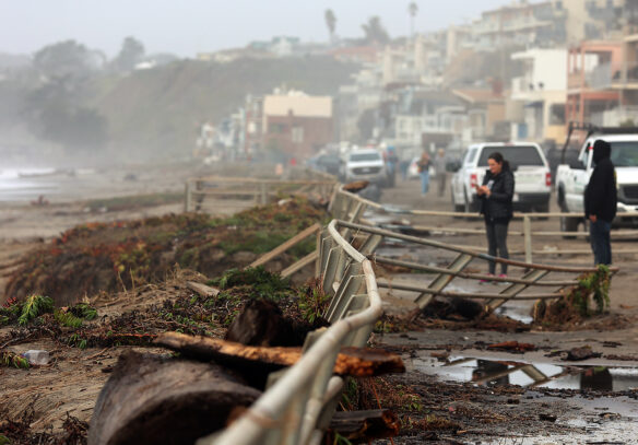 The damaged metal fencing and railings along Beach Drive illustrate the power unleashed by Thursday’s storm as visitors take in the scene Friday morning © Shmuel Thaler - Santa Cruz Sentinel