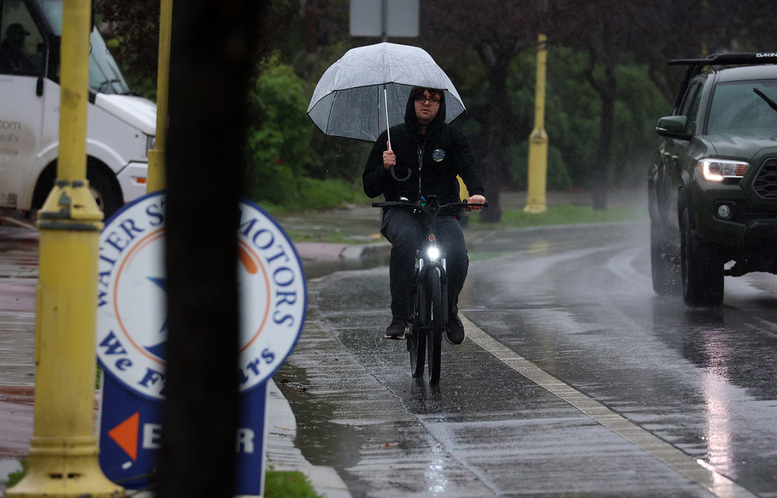 A cyclist tries to keep the rain at bay on Wednesday while pedaling on River Street in Santa Cruz © 2023 Shmuel Thaler - Santa Cruz Sentinel
