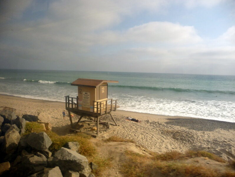 Sunday Afternoon on the Pacific Surfliner: View of Beach & Lifequard Tower, Orange County (by Joe Wolf CC BY-ND 2.0 via Flickr).
