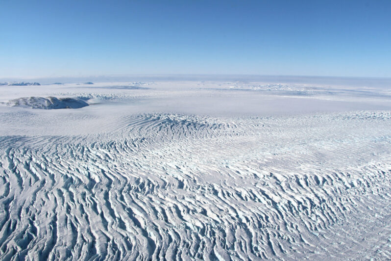 Ice accelerating as it flows towards the coast creates heavy crevassing near the coast of Melville Bay in west Greenland (by John Sonntag/NASA’s Operation IceBridge courtesy of NASA Earth Observatory, public domain).