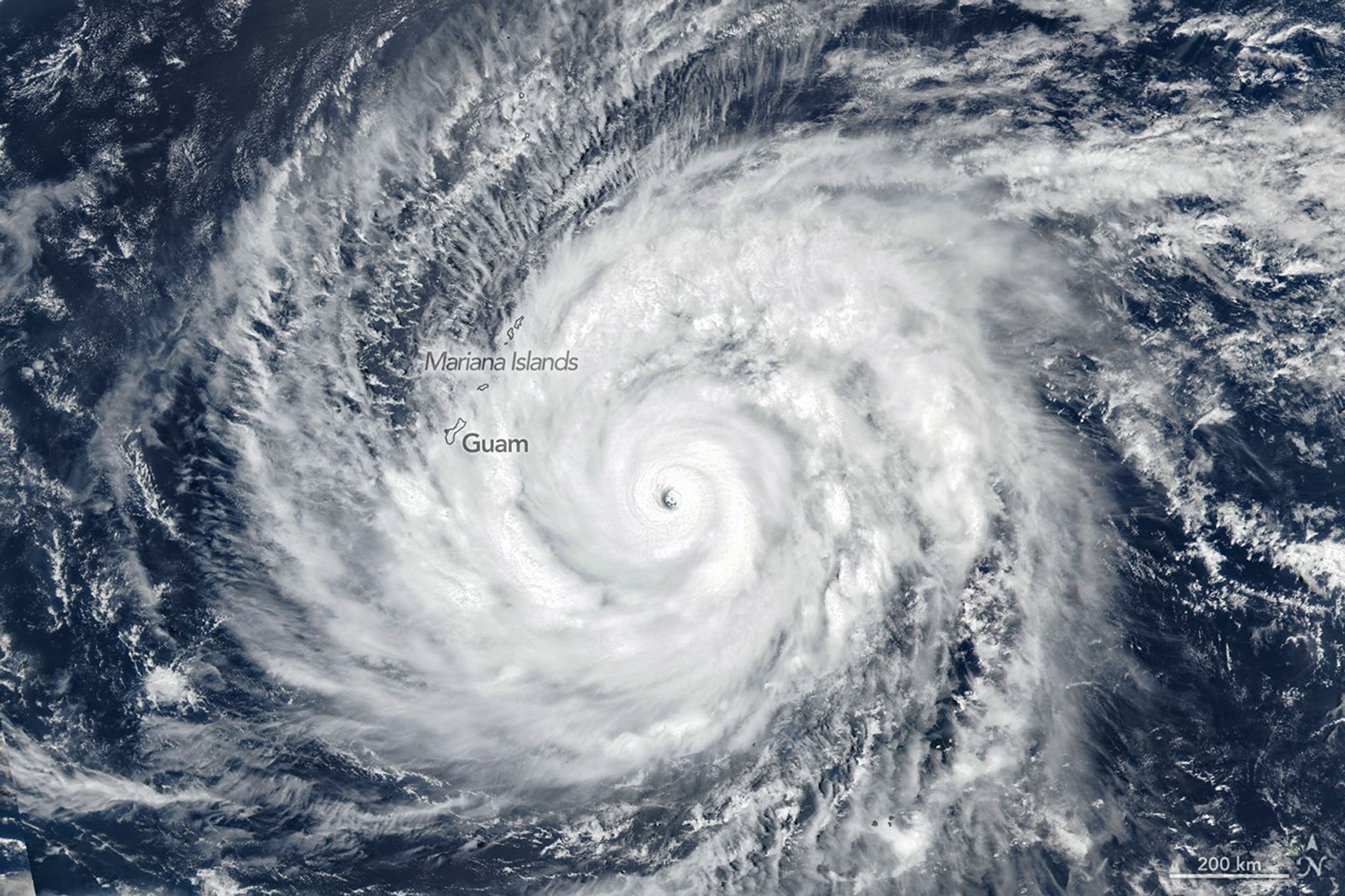 Super Typhoon Sinlaku spins over the North Pacific Ocean in this image acquired on April 13, 2026, with the VIIRS (Visible Infrared Imaging Radiometer Suite) on the Suomi NPP satellite. (courtesy of NASA Earth Observatory | Michala Garrison, public domain).