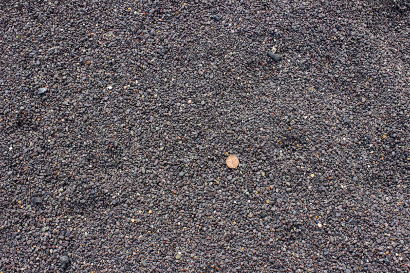 Figure 4. Surface of the stamp sand deposit. Note that much of the sediment appears coarser than “sand” (granule size), but there are significant amounts of sand, silt and clay. Portions of the tailings pile have a slightly purplish color which Kerfoot et al. (2012) attribute to the iron-oxidized clay fraction. [Penny for scale]